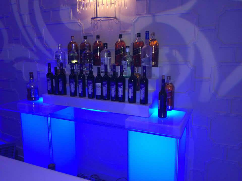 A bar with many bottles of alcohol on top