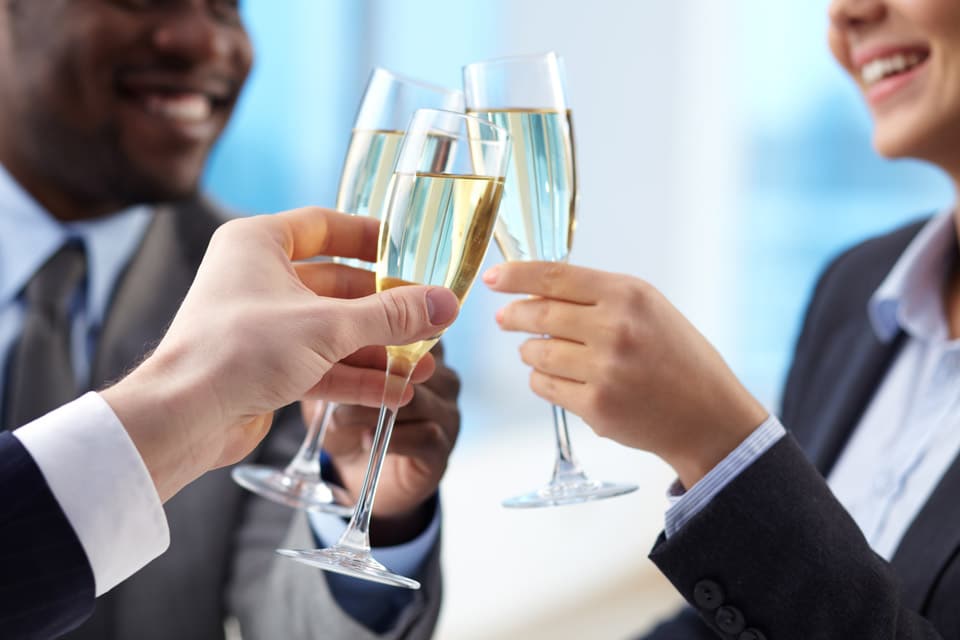 A group of people holding champagne glasses.