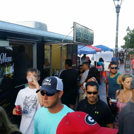 A group of people getting a drink from a mobile alcohol truck