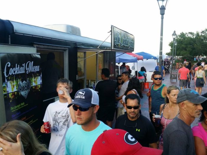 A group of people getting a drink from a mobile alcohol truck